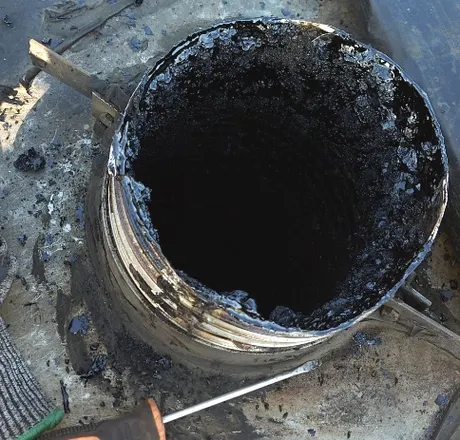 Conduit de fumée tubé encrassé de bistre noir et croûteux, avant débistrage